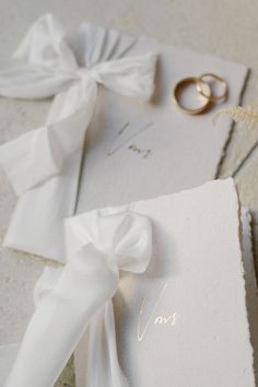 two wedding rings on top of a white card