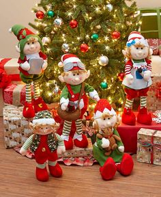 the christmas tree is decorated with red, green and white stockings as well as little elves