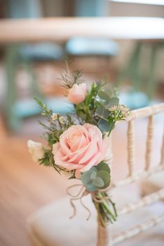 a bouquet of pink roses sitting on top of a white chair next to a table