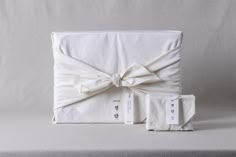 a white box wrapped in linen and tied with a bow