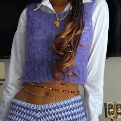 a woman with braids wearing a purple sweater and skirt