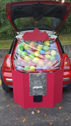 a red car with its hood open filled with candy