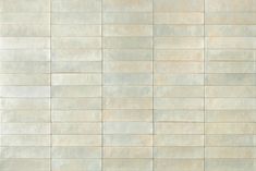 a white tile wall textured with light blue and beige tiles in an irregular pattern