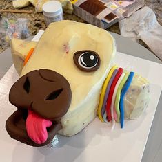 a cake shaped to look like a dog with its mouth open and tongue hanging out