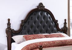 a bed with a black headboard and red bedspread