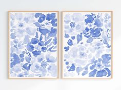 two blue and white floral paintings hanging on a wall