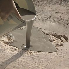 a person is pouring cement into a bucket