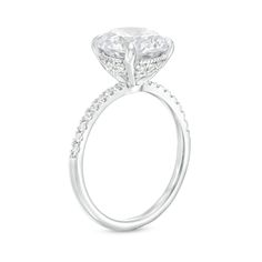 a white gold ring with an oval cut diamond and pave set diamonds on the side