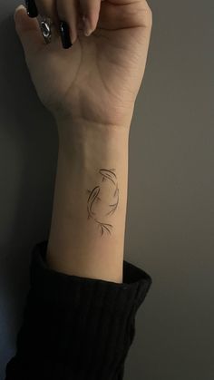 a woman's arm with a small wrist tattoo on the left side of her hand