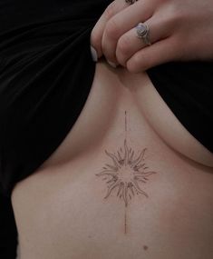 a close up of a person's stomach with a sun tattoo on her back