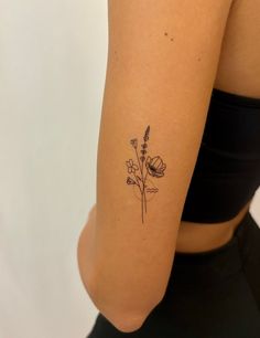 a woman with a flower tattoo on her left arm and right arm behind her back