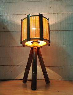 a lamp that is sitting on top of a wooden table next to a white wall