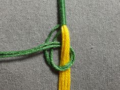 a yellow and green piece of cloth with a knot at the end that has been knotted together