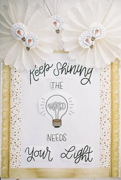 a sign that says keep shining the needs your light on it with paper flowers around it