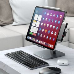 an apple computer sitting on top of a table next to a keyboard and mouse with a couch in the background