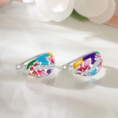 This beautifully detailed earring boasts charming butterflies and flowers in bright shades of multicolored enamel. The intricate flawless enamel work coupled with white stones, make this an eye-catching piece. Inspired by the serene beauty of nature, this ring will brighten up even the dullest of days in your life. With a myriad of colours everywhere, why not add some to your jewelry box with beautiful enamel jewelry.Carat Weight: 0.238 ctStone Size: 1,0.8 mmStone Type: Jeulia® StoneNumber of St Multicolor Enamel Earrings, Multicolor Enamel Flower Earrings, Multicolor Flower Enamel Earrings, Enamel Clip-on Earrings As Gift, Dreamy Garden, Butterflies And Flowers, White Stones, Butterfly Flower, Sterling Silver Hoop Earrings