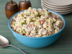 a blue bowl filled with macaroni salad on top of a table