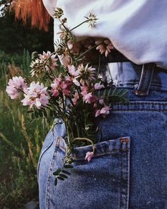 a woman is holding flowers in her back pocket