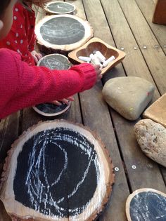 children are playing with chalk on wood slices