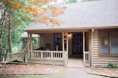 a small house in the woods with porches and steps leading up to it's front door