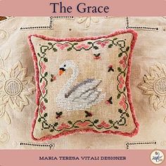 an embroidered pillow with a white swan on it and the words,'the grace '