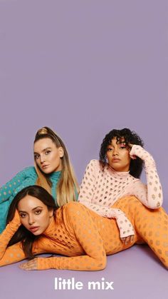 three women laying on the ground in matching outfits