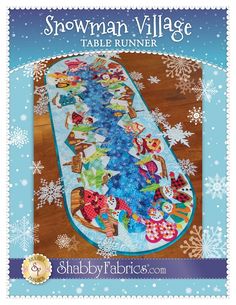 the snowman village table runner pattern is shown in blue and white with snowflakes on