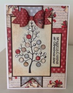 a christmas card with a red bow on it and a tree made out of buttons