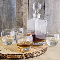 four glasses and a decanter on a wooden tray