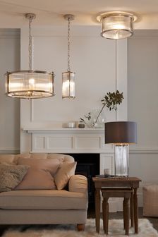 a living room with two couches and three lights hanging from the ceiling above them