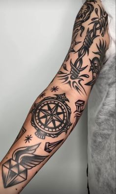 a man's arm with tattoos on it and an image of a compass in the middle