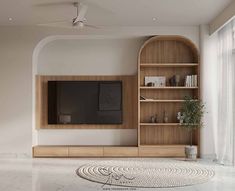 an empty living room with a large tv on the wall and wooden bookshelves