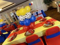 a table set up for a party with balloons