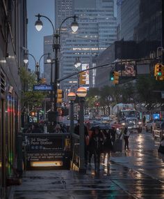 people are walking down the street in the rain