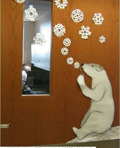 a polar bear is blowing snowflakes on the door