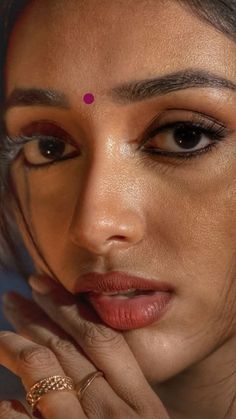 a close up of a woman with her hand on her face and the other hand under her chin