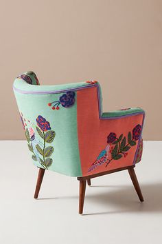 a colorful chair sitting on top of a white floor next to a pink and blue wall