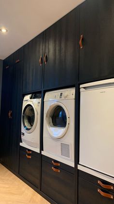 several washers and dryers are lined up against the wall in this laundry room