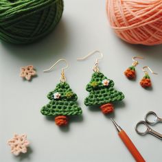 crochet christmas tree earrings with scissors and ball of yarn