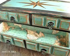 an old world map dresser is painted green and has two drawers on each side with knobs