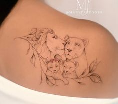 a woman's back with a lion and cubs tattoo on it