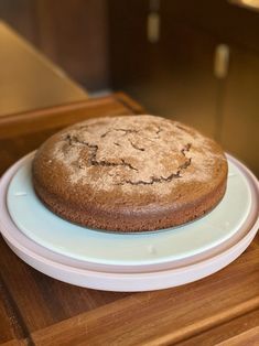 a chocolate cake sitting on top of a white plate next to a wooden countertop