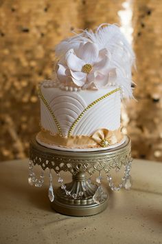 a white and gold wedding cake on a table