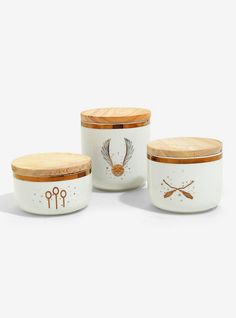 three canisters with spoons and scissors painted on the sides, one is white