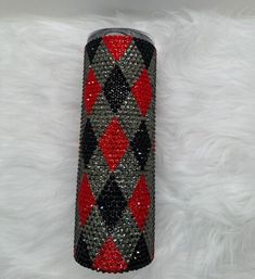 a red, black and silver can with some diamonds on it