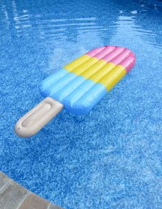 an inflatable pool float sitting on top of a blue and yellow swimming pool