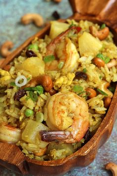 a wooden bowl filled with rice and shrimp