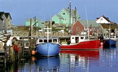 several boats are docked in the water near houses