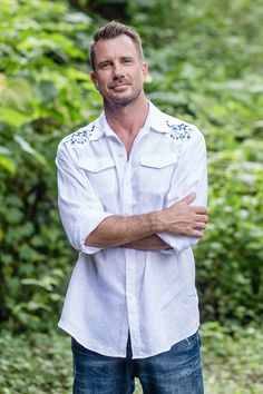 Designed by Made Suciati in Bali, this crisp white shirt is crafted from 100% linen. Accented by hand-embroidered flowers on each shoulder, the button-up shirt features long sleeves, a collared neckline, and two patch pockets on the chest. Linen Shirts For Men, Flower Pants, Australian Men, Men Fashion Casual Shirts, Hand Embroidered Flowers, Linen Shirts, Linen Shirt Men, Male Hands, Crisp White Shirt