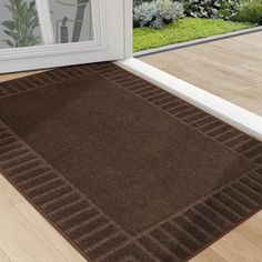 a brown area rug sitting on top of a hard wood floor next to a door